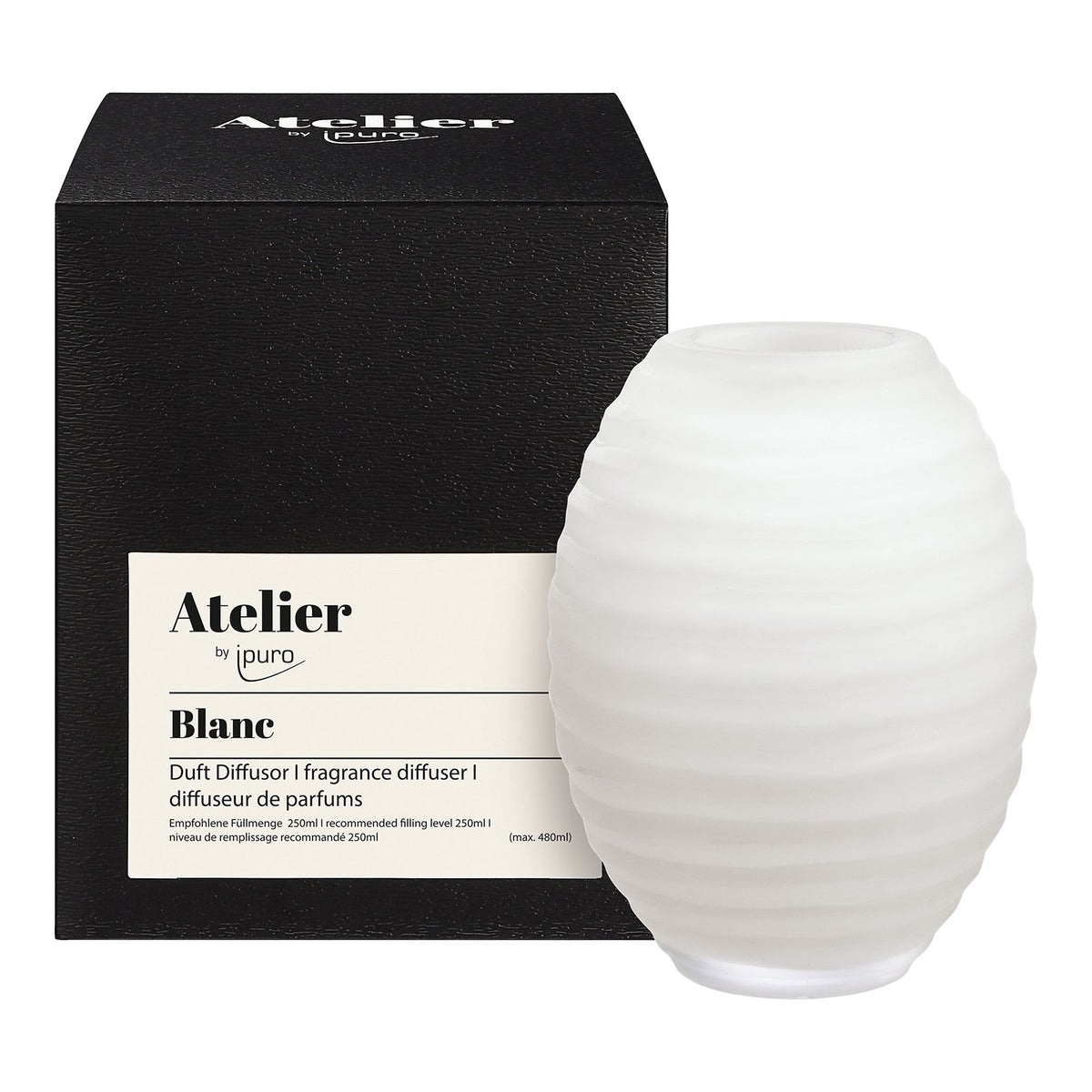 Der ipuro Atelier by ipuro blanc Diffusor, ein weißer gerippter Glasduftdiffusor, wird vor seiner schwarzen Schachtel mit mehrsprachigen Produktbeschreibungen präsentiert.