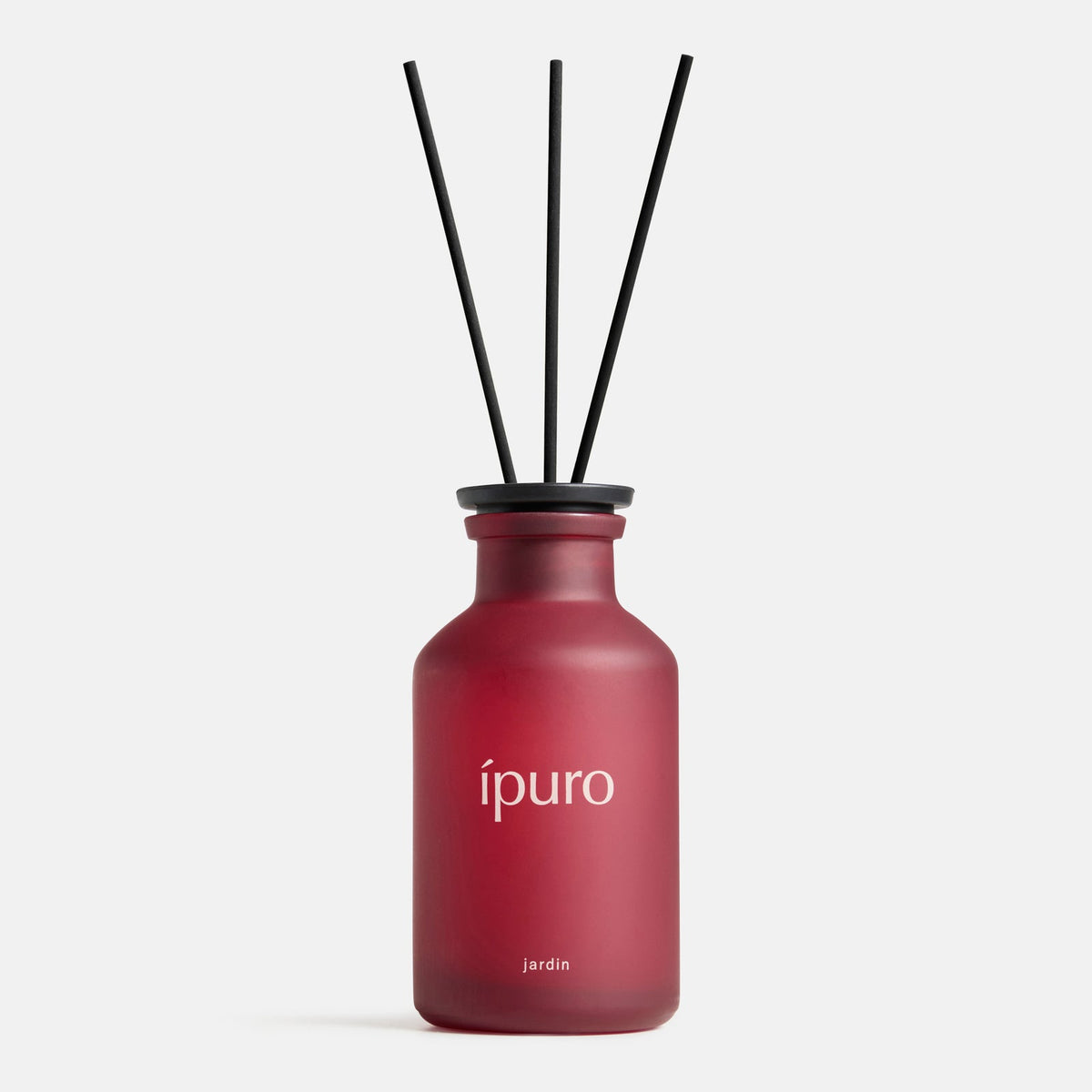 Ein rotes Milchglas ipuro Raumduft CLASSIC jardin diffuser bottle mit der Aufschrift "ipuro" und drei schwarzen Schilfrohrstäbchen erinnert an exotische Blüten aus einem verborgenen Garten, dargestellt auf einem schlichten weißen Hintergrund.