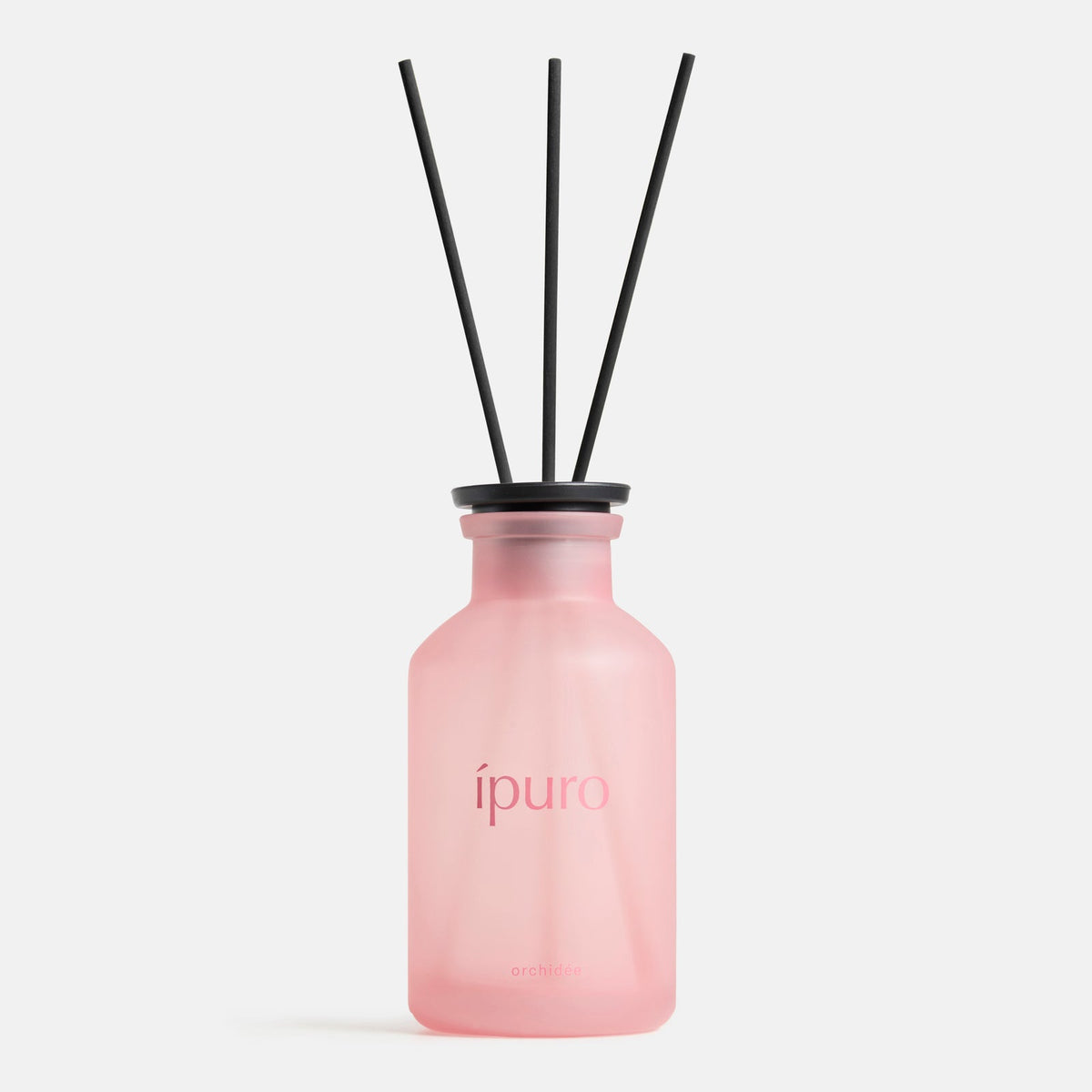 Ein rosafarbener Milchglasflakon mit der Aufschrift ipuro orchidée by ipuro enthält schwarze Diffusorstäbchen, die einen Duft von sizilianischer Zitrone und zartem Veilchen in die Luft abgeben.