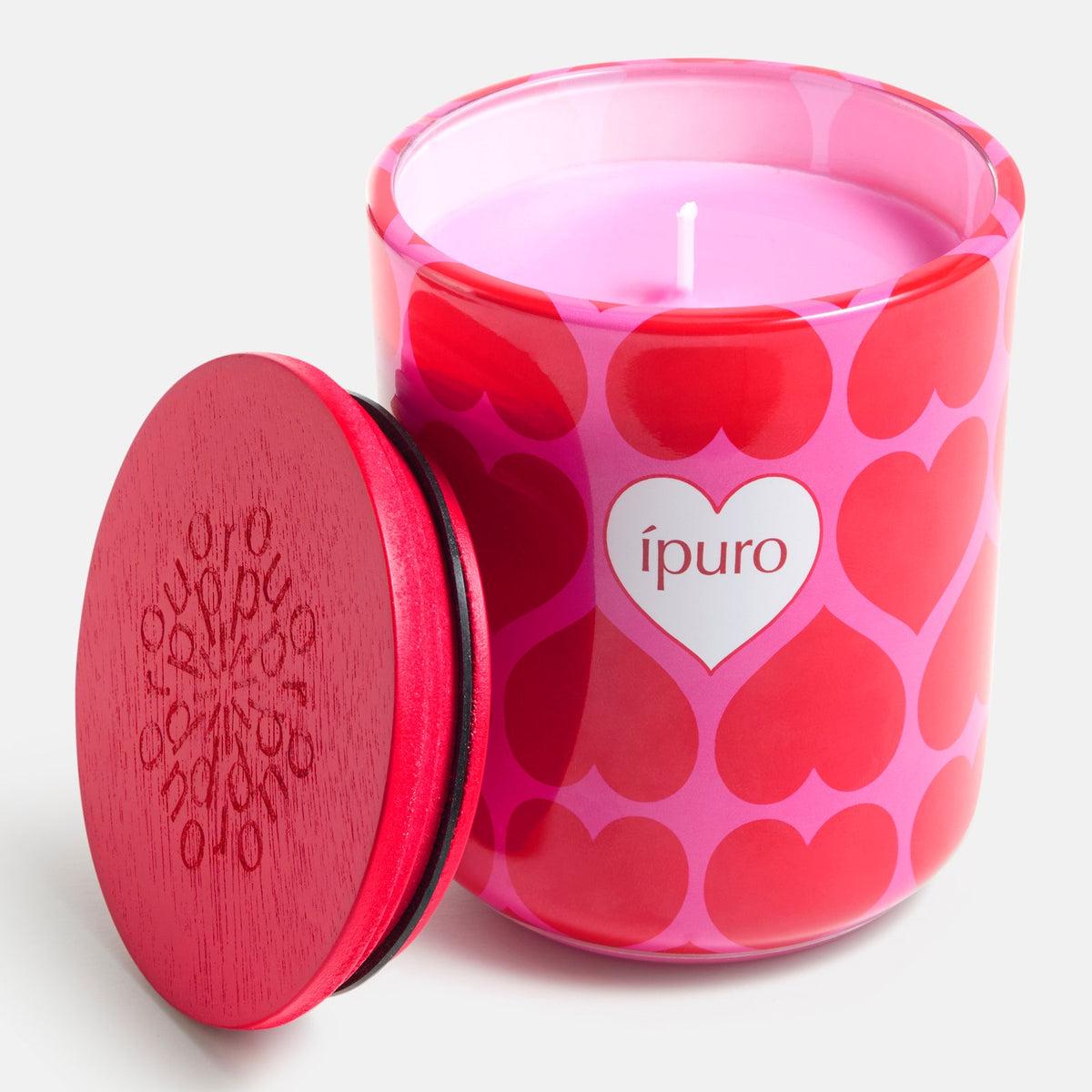 Die ipuro Kerze love's embrace 270g ist eine rosafarbene Kerze in einem Glasgefäß mit roten Herzen und einem weißen ipuro-Etikett in Herzform. Sie duftet nach Sandelholz und Blumenbouquet und wird von einem roten Holzdeckel mit geprägtem Schriftzug gekrönt.
