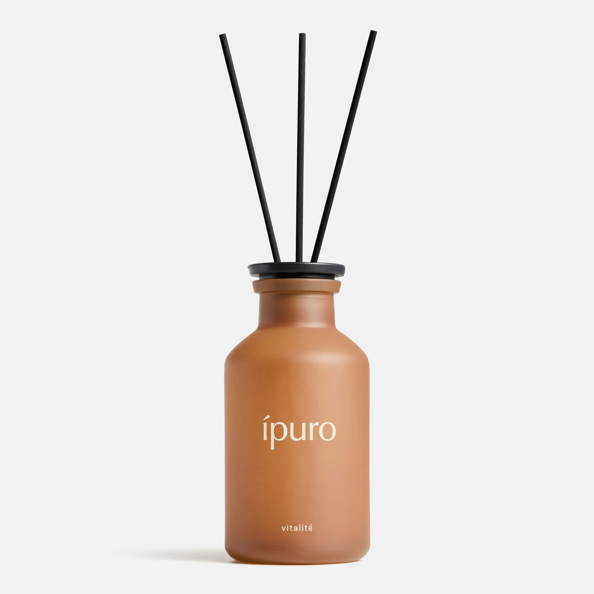 Ein brauner Milchglasflakon mit der Aufschrift "ipuro" und einer schwarzen Kappe enthält drei schwarze Diffusorstäbchen, die das Raumduft ipuro vitalité präsentieren. Der minimalistische weiße Hintergrund erinnert an die wohltuenden Düfte und das pure Wohlbefinden der Marke ipuro.